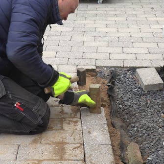 Fliserne skrider: Den sidste række, der ligger på tværs af de øvrige fliser, slås på plads Fliserne skrider: Den sidste række, der ligger på tværs af de øvrige fliser, slås på plads